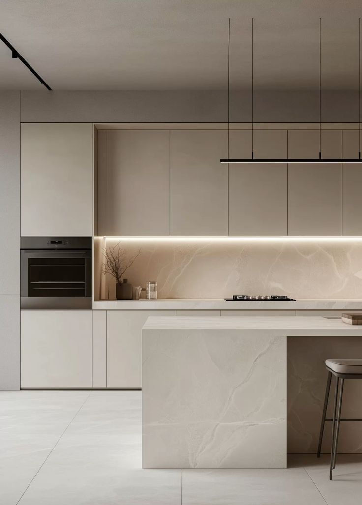 Minimalistička bijela kuhinja s bež kabinetima i otočkom. Ugodna LED svjetla, crna viseća rasvjeta, moderna pećnica, skroman i čist dizajn.