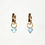 Thumbnail: Gold hoop earrings with light blue gem charms.
