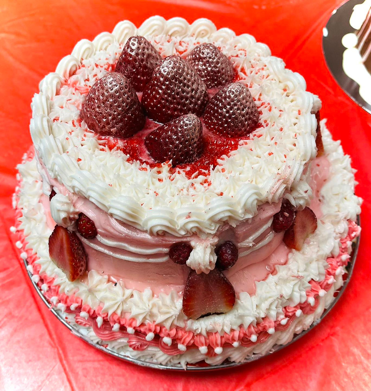 cake with pink and white icing and strawberries