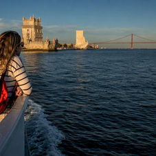Passengers viewing Lisbon landmarks from the Tagus