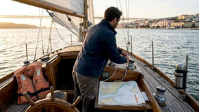 Lisbon skipper adjusts sail on vintage boat