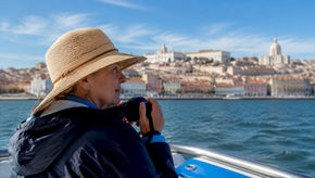 Tourist on boat viewing Lisbon landmarks from Tagus River