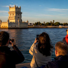 Visitors photographing Lisbon landmarks from sailboat