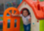 Niña pequeña jugando en una casita de juegos del área de preescolar del Institute Queen Victoria en Cancún.