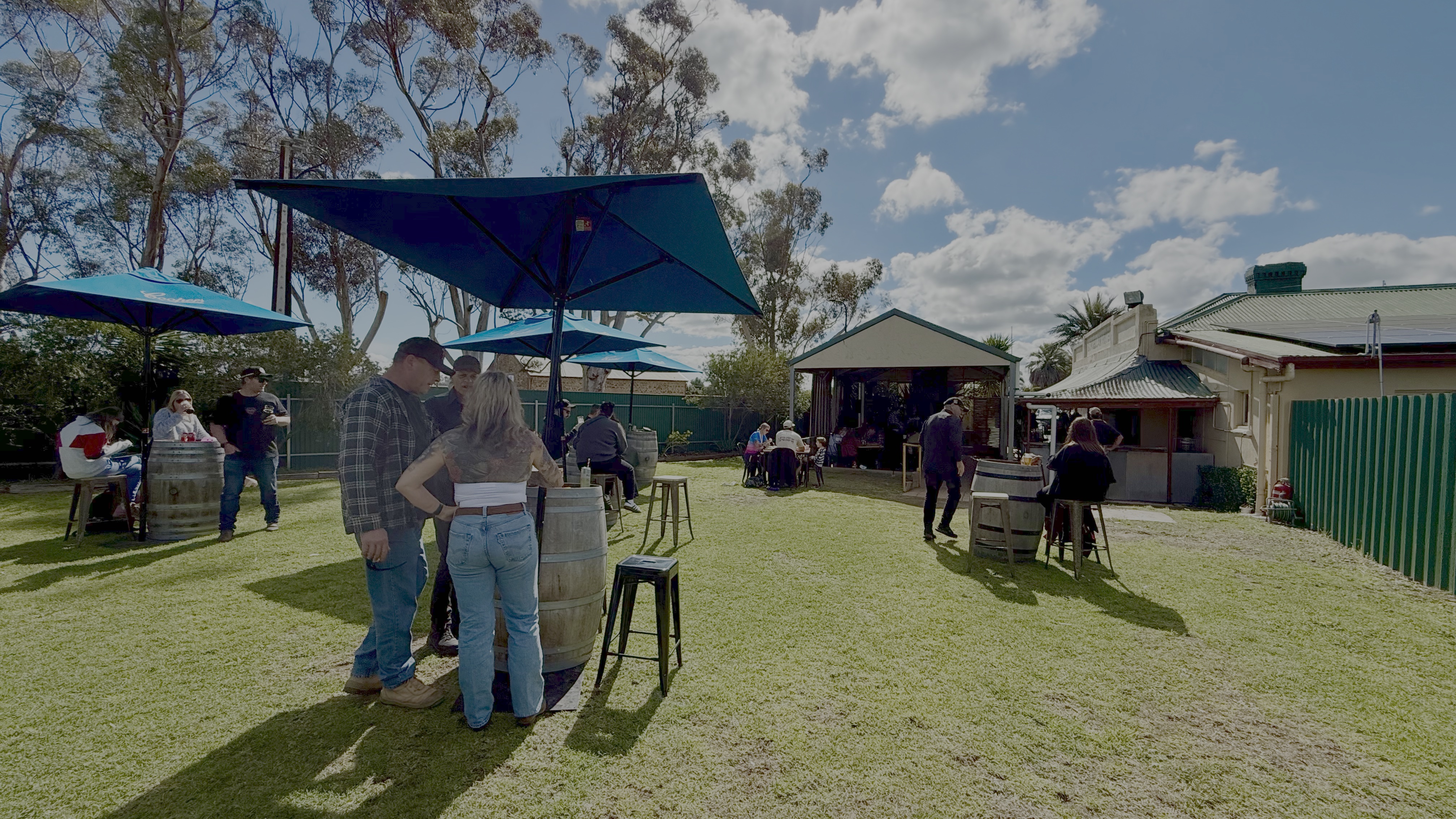 The beer garden at the Gungellan Hotel, with umbrellas and wine-barrel tables on the lawn