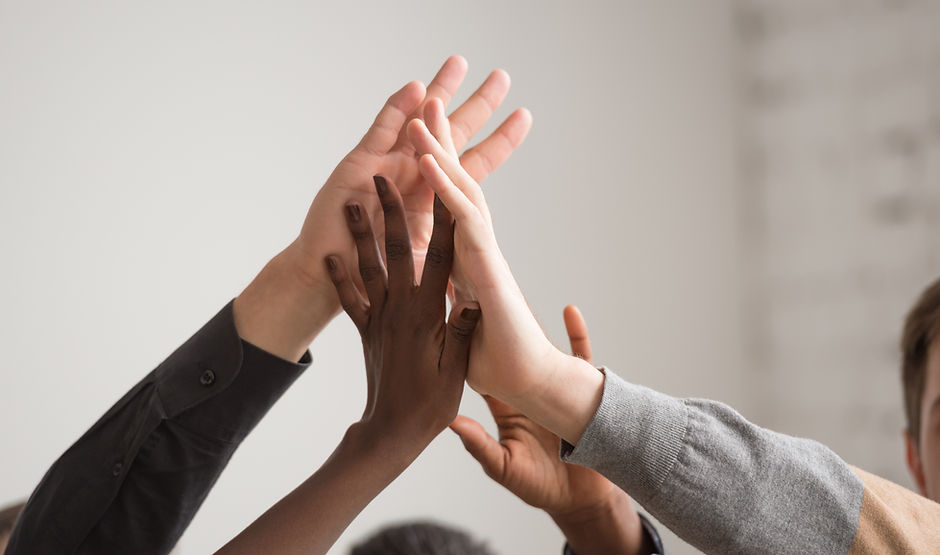 Vier Hände machen ein High Five.