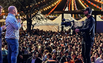 Camarógrafo con estabilizador produciendo evento en vivo con público masivo