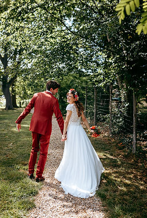 Couple de marié qui dansent dans une allée bouquet à la main