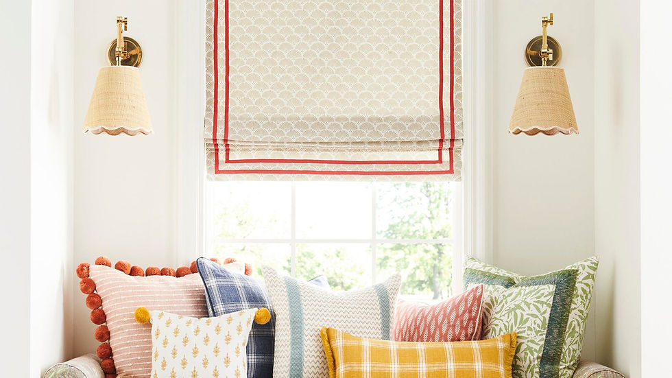 Window nook with red-trimmed Roman shade and colorful pillows