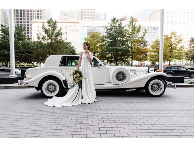 bride standing next to white Excalibur vehicle 