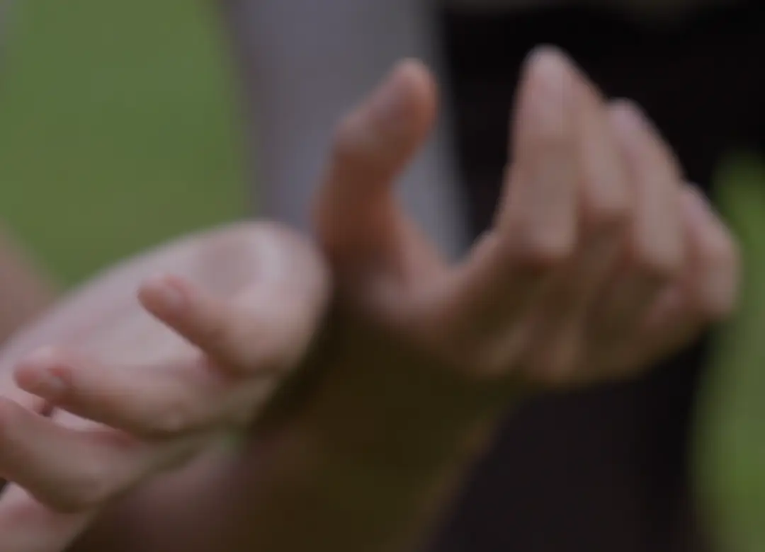 Two hands reaching gently toward each other
