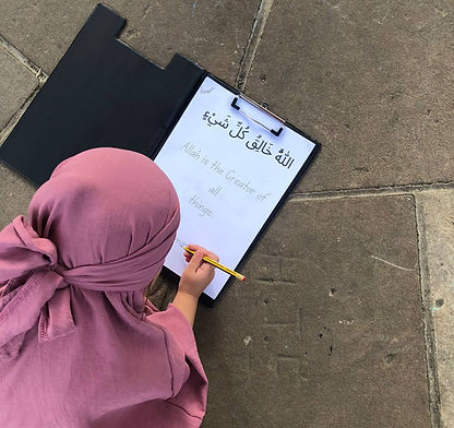 A Muslim child completing an Islamic handwriting worksheet about Tawheed, learning that Allah is the Creator of all things. Ideal for homeschool families, Islamic schools, and weekend madrasahs.