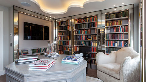 reflective foxed mirror wall in home library adding depth and character