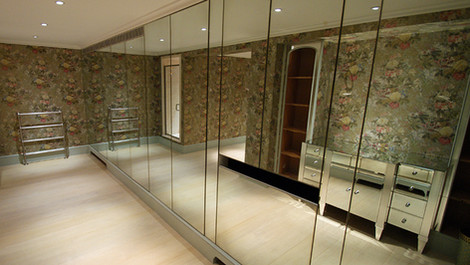 fitted antique mirror wardrobes in luxury dressing room reflecting light and creating a spacious effect