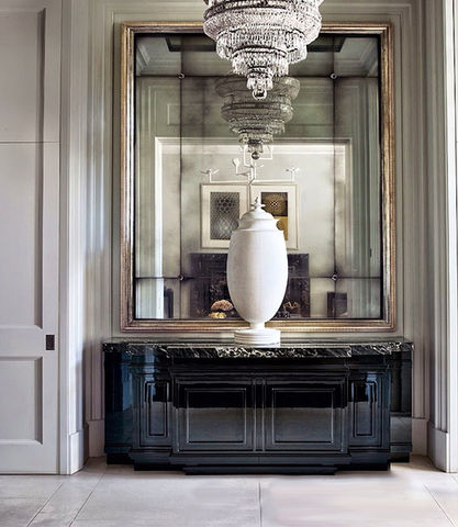 custom-designed mirror feature wall with chandelier and console table, enhancing light and luxury in entrance hall