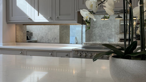 Smoked antique mirror splashback by Mirror Works in a modern kitchen, handcrafted and toughened for a refined, timeless look.