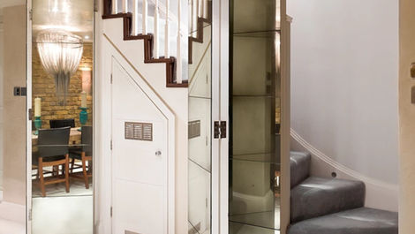 vintage mirror wall under staircase reflecting light and adding depth to hallway