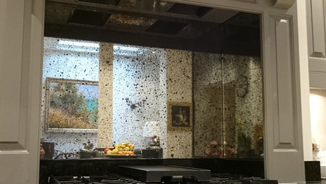 Classic kitchen with handcrafted antique mirror splashback behind a large range cooker, custom made and fitted by Mirror Works.