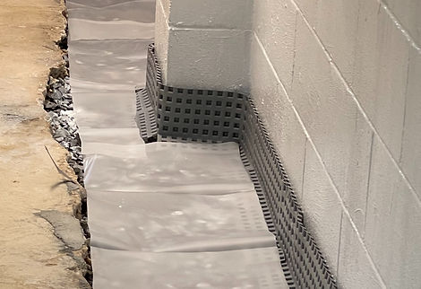 Vapor barrier over basement French drain system