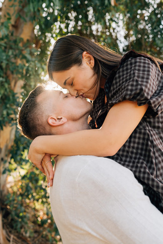 A couple kissing under a willow tree