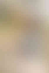 Three young kids climbing on a rock and hugging each other