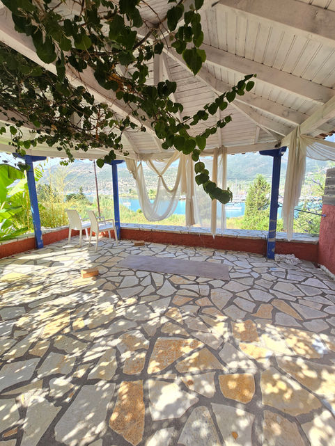Balcon couvert avec sol en pierre et hamac dans un authentique hôtel de charme au cœur de Geni