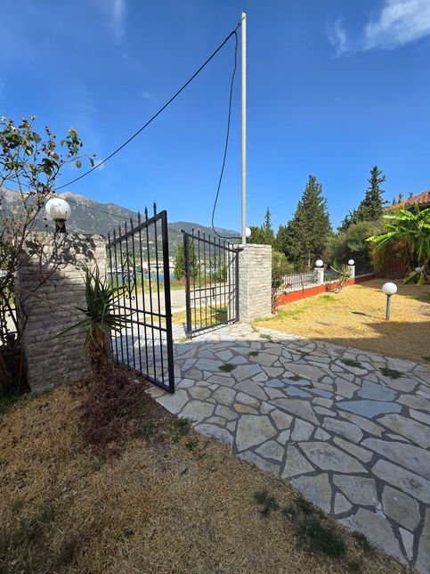 Entrée d'un authentique hôtel de charme a Geni, avec un portail en fer forgé et vue sur les montagnes.