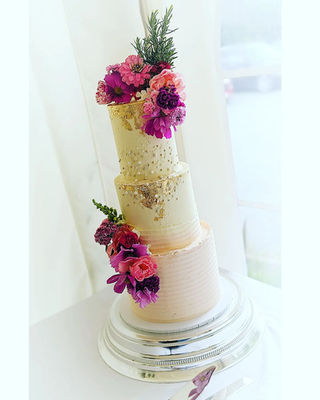 Pink buttercream wedding cake with hot pink flowers