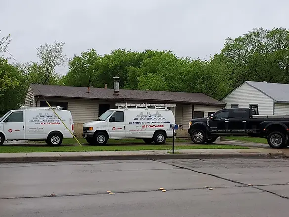 Three service vans and a truck parked outside a house with contact details.