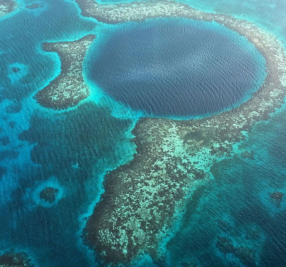 Aerial view of the Great Blue Hole surrounded by vibrant coral reefs.