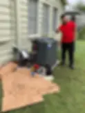 Man in red shirt points to the air conditioner for service Fort Worth Air.