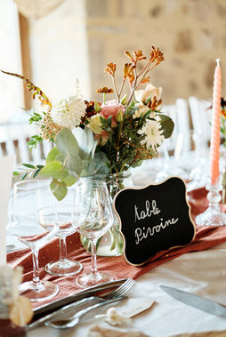 Belle table décorée avec fleurs et bougies, texte "table divine" MARIAGE, ambiance festive.
