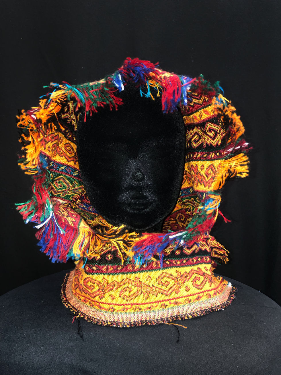 Capuche coloré à motifs avec un bout pointu. Deux bandes longues de chaque cotés.