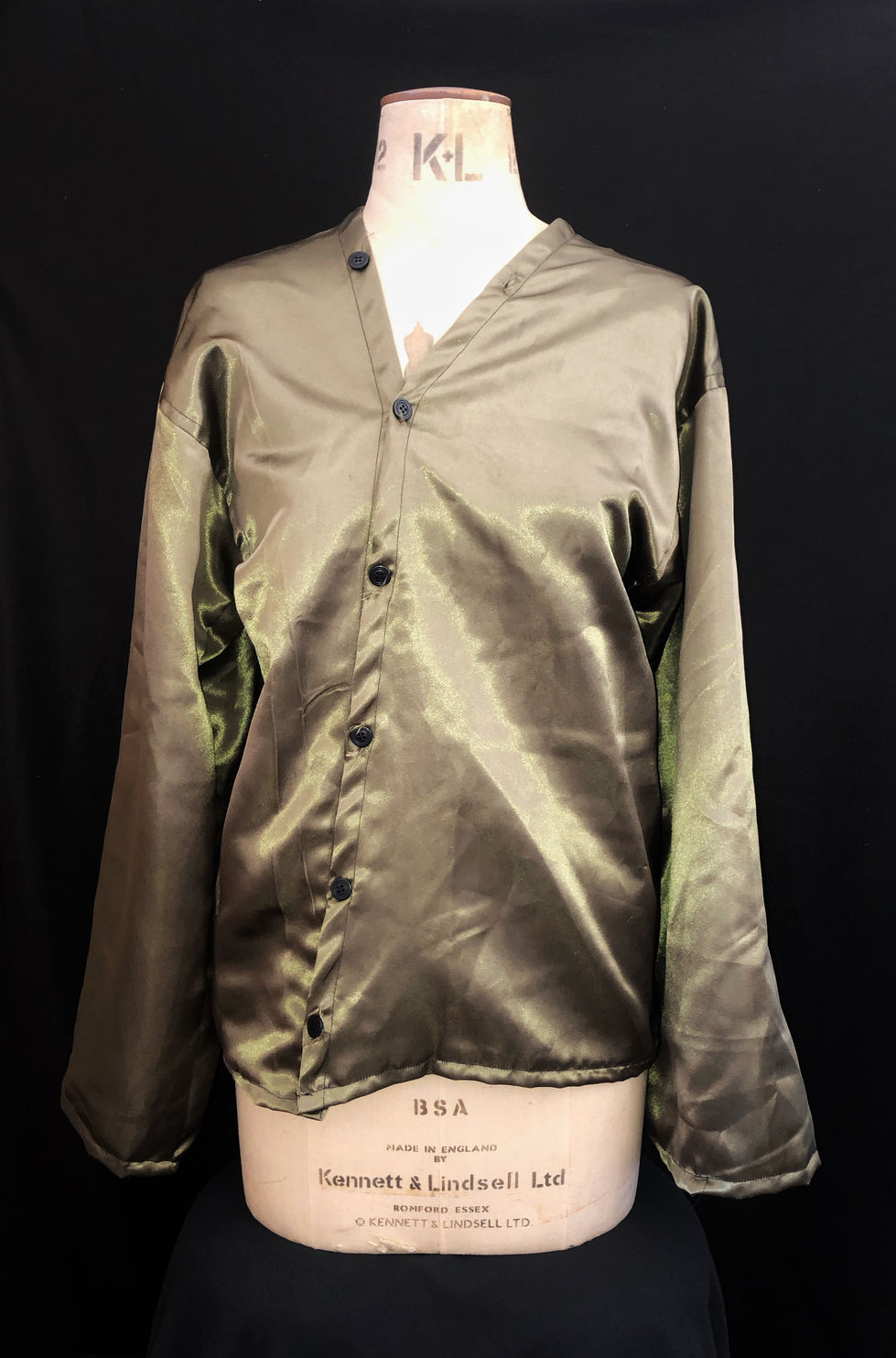 Chemise en satin avec une boutonnière tout le long de la chemise. Boutonnière en travers de la chemise. Manches larges.