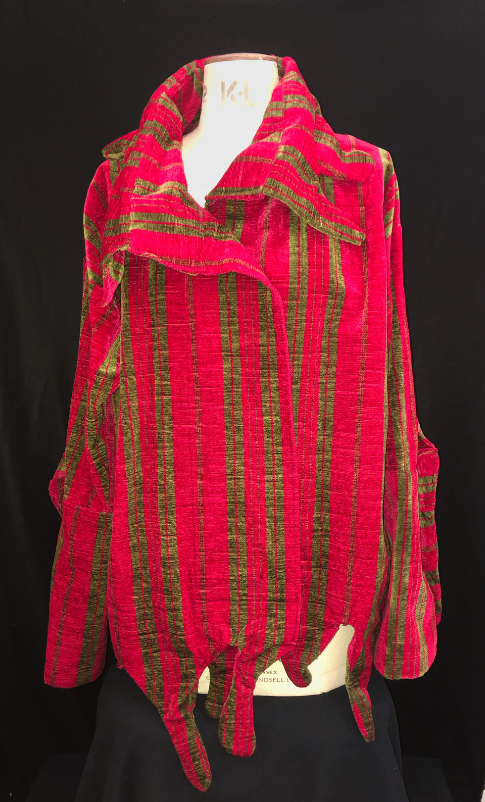 Veste dans un style de chemise plutôt large avec le col et le bas taillés en gouttes. Tissu issue d'un rideau de château. Veste sans fermeture et manches longues sans fermetures.