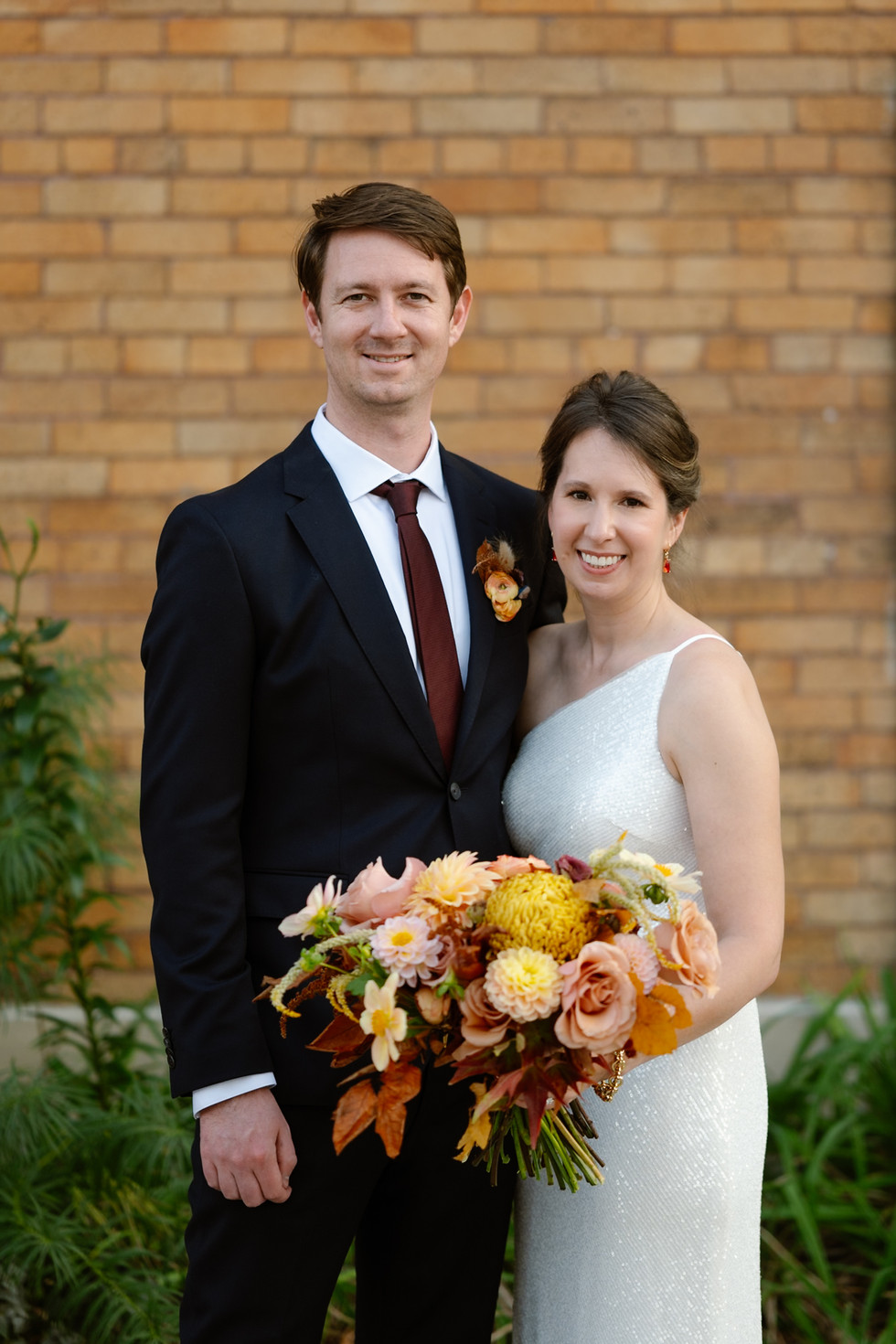 Harvey House Wedding bride and groom in front of brick wall