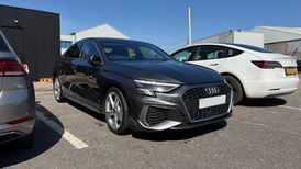 Dark grey Audi A3 parked in an outdoor lot on a sunny day.