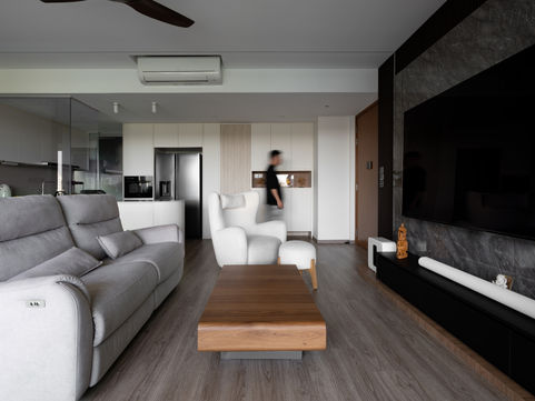 a living room with a gray couch and white chairs