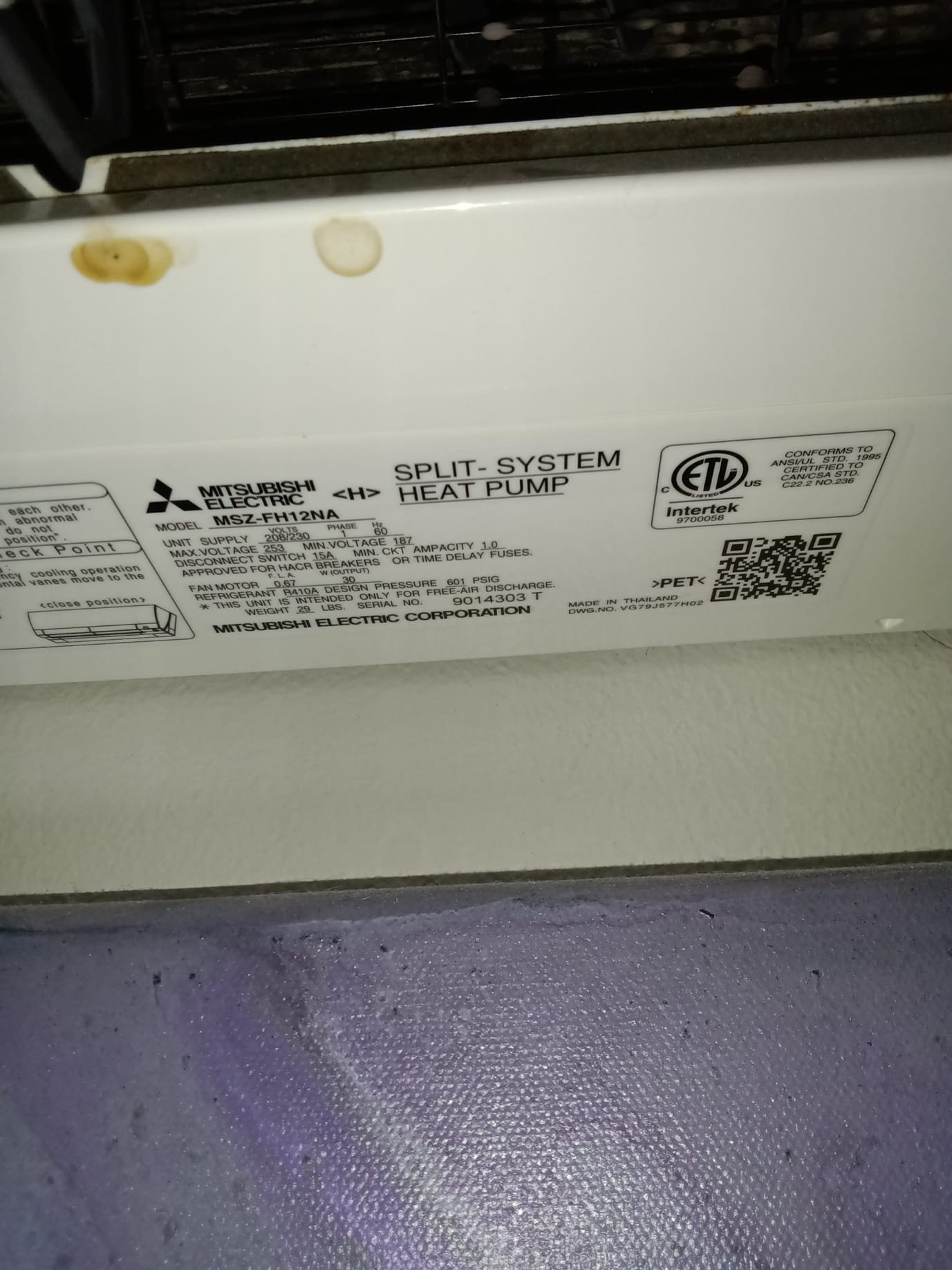 A homeowner smiles, holding a spigot repair kit next to a smoke-damaged wall partially repaired. The repaired section is clean and bright, contrasting with the remaining smoke stains, suggesting the homeowner is empowered to start the smoke repair themselves before considering professional help for extensive damage.