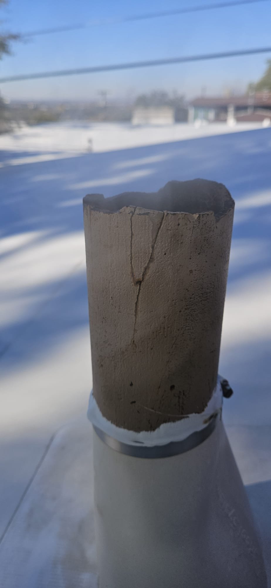 A close-up of a clean, new septic backflow valve installed on a pipe. The valve's pristine condition implies effective prevention of sewage backflow, contributing to sewage odor removal. The visual emphasizes the valve as a reliable sewage odor neutralizer by stopping the source.