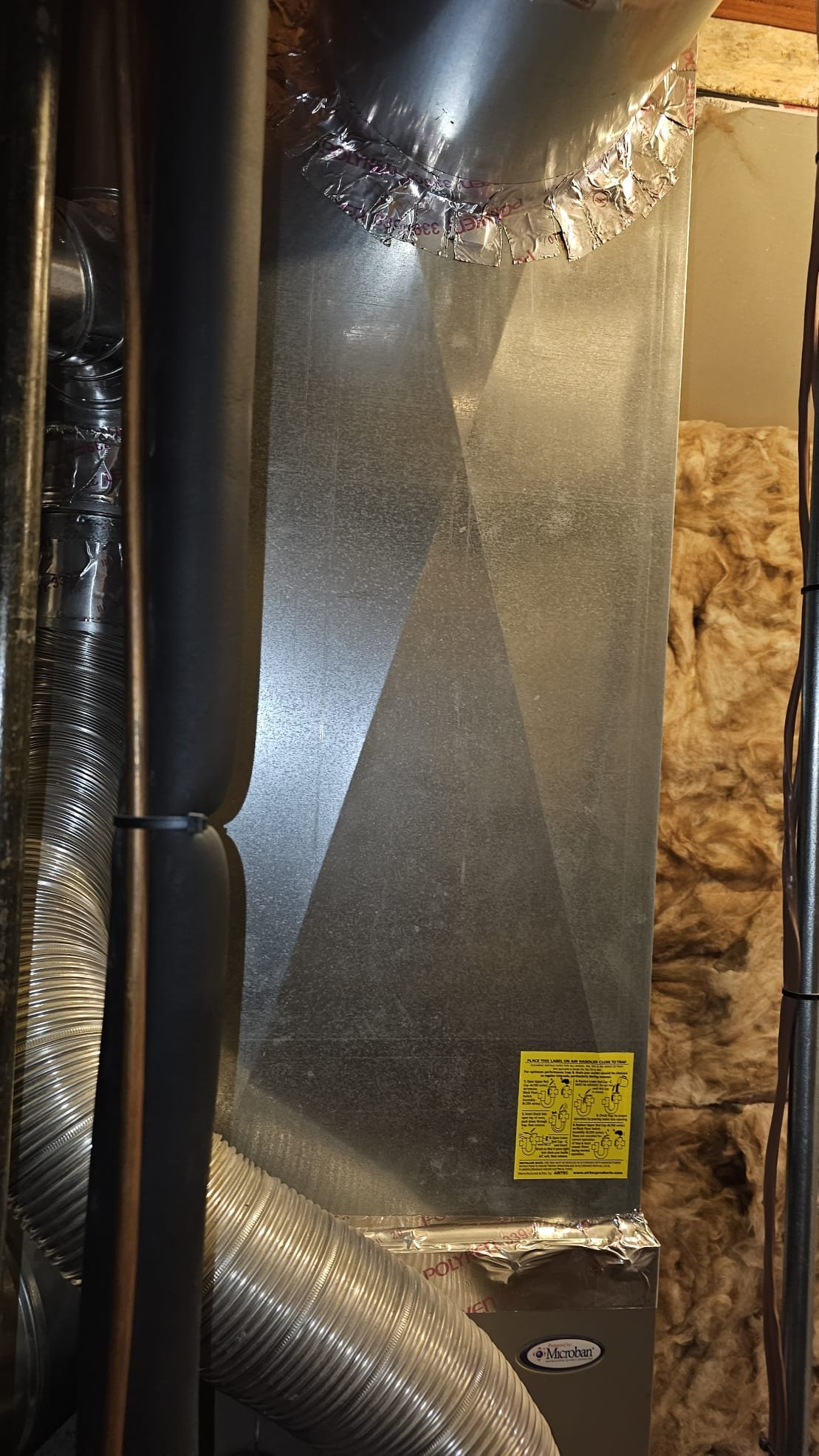 Image of a pristine, newly repaired wall in a bright, modern home, subtly showcasing a water softener system in the background. The scene emphasizes dryness and cleanliness, implying successful drywall water damage recovery and highlighting the long-term benefits of a home water softener in preventing future issues. The overall impression is one of peace of mind and a well-maintained home.