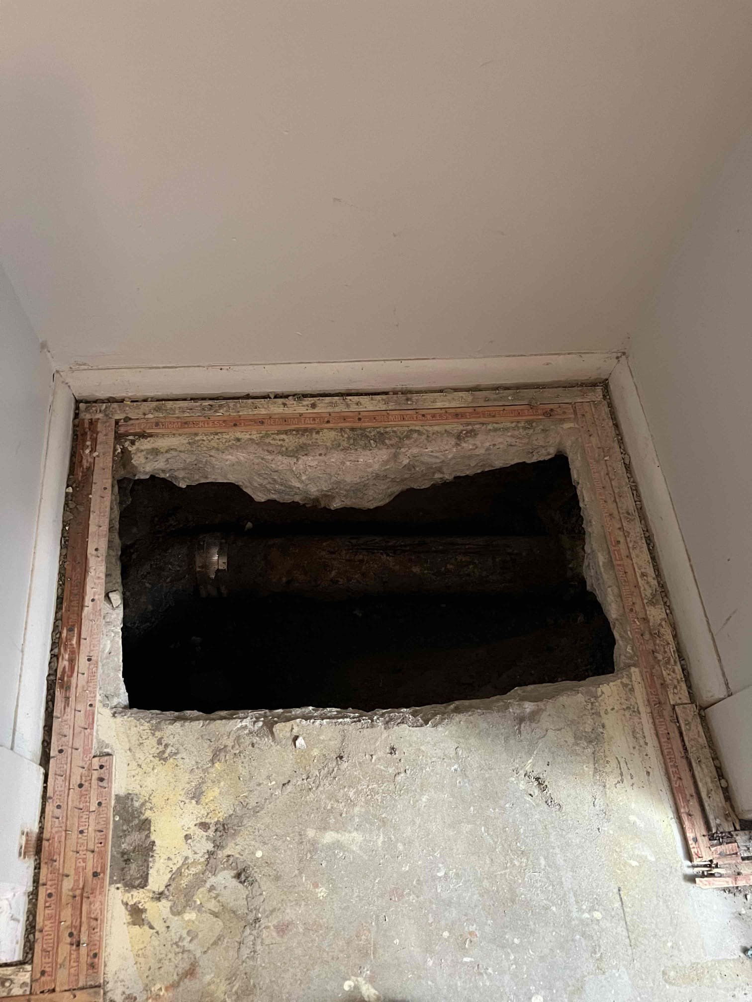Aftermath of a basement flood. Restoration team uses professional equipment to extract water, revealing clean, dry flooring underneath. Promotes the benefits of fast, effective emergency flood recovery services.