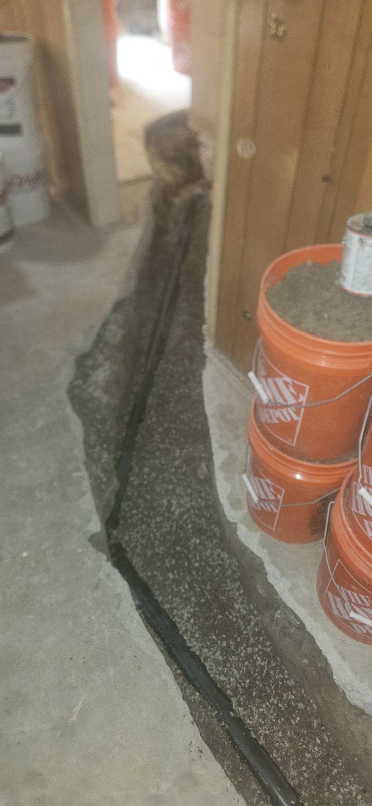 Image of a clean, bright basement after mold abatement in Minneapolis. A technician wearing a protective mask is carefully inspecting the treated area, highlighting the professional service for basement mold damage and the importance of safety during the process.