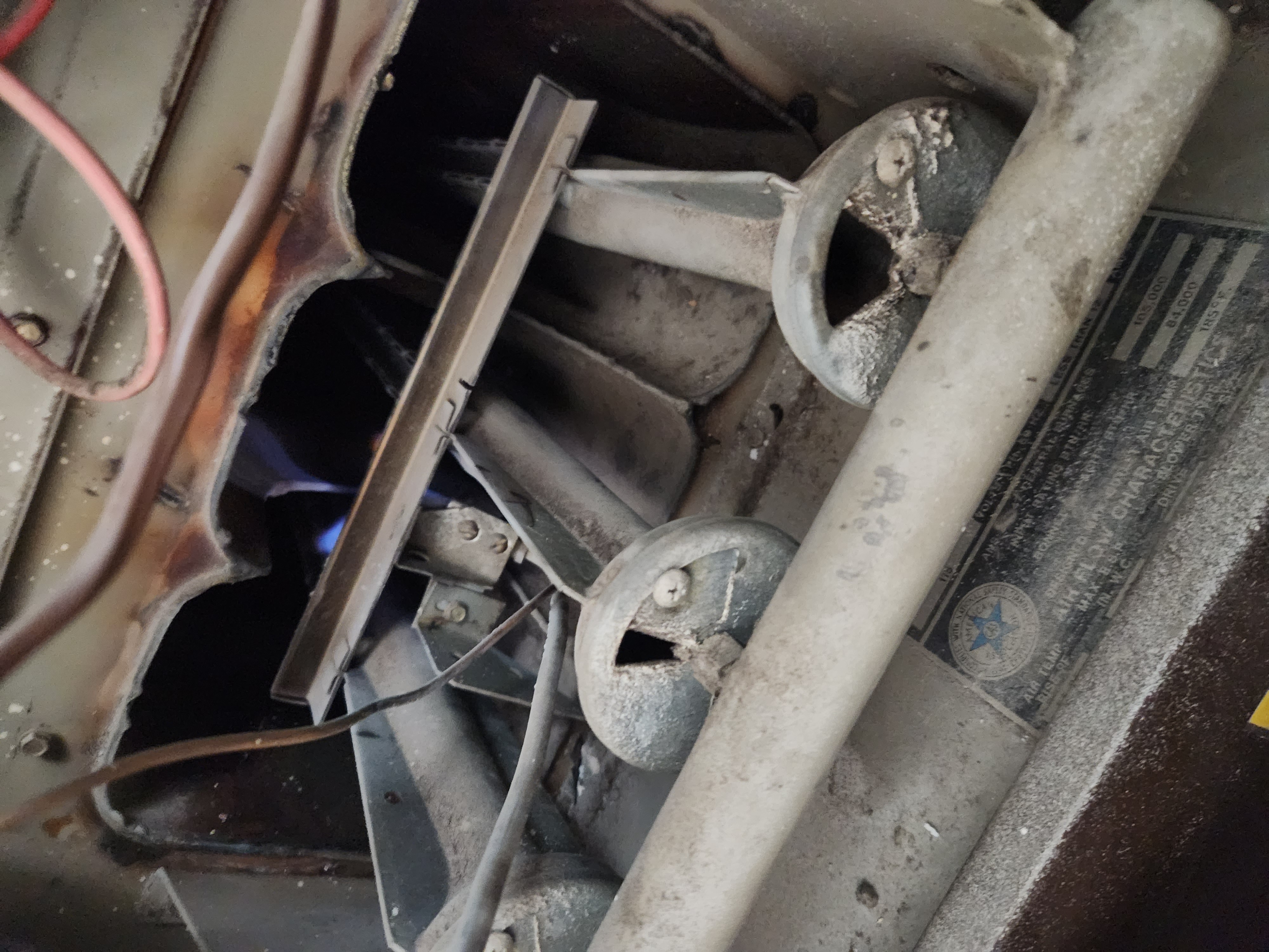 An outdoor wood-burning furnace sits near a stack of clean furnace filters, implying efficient heating. In the background, a well-maintained home suggests the benefits of regular residential furnace inspection services.