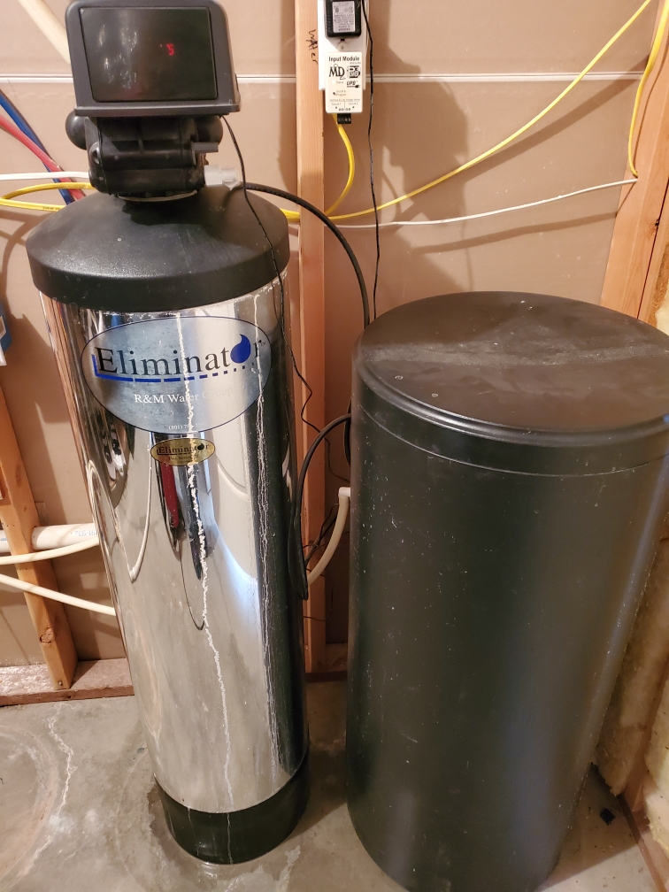 Water softener plumbing loop in a Woods Cross, Utah home. Adequate clearance around the unit is essential to prevent issues. This setup helps manage water pressure and allows for easy maintenance, crucial to avoid water softener leaking water common in Davis County homes with hard water.