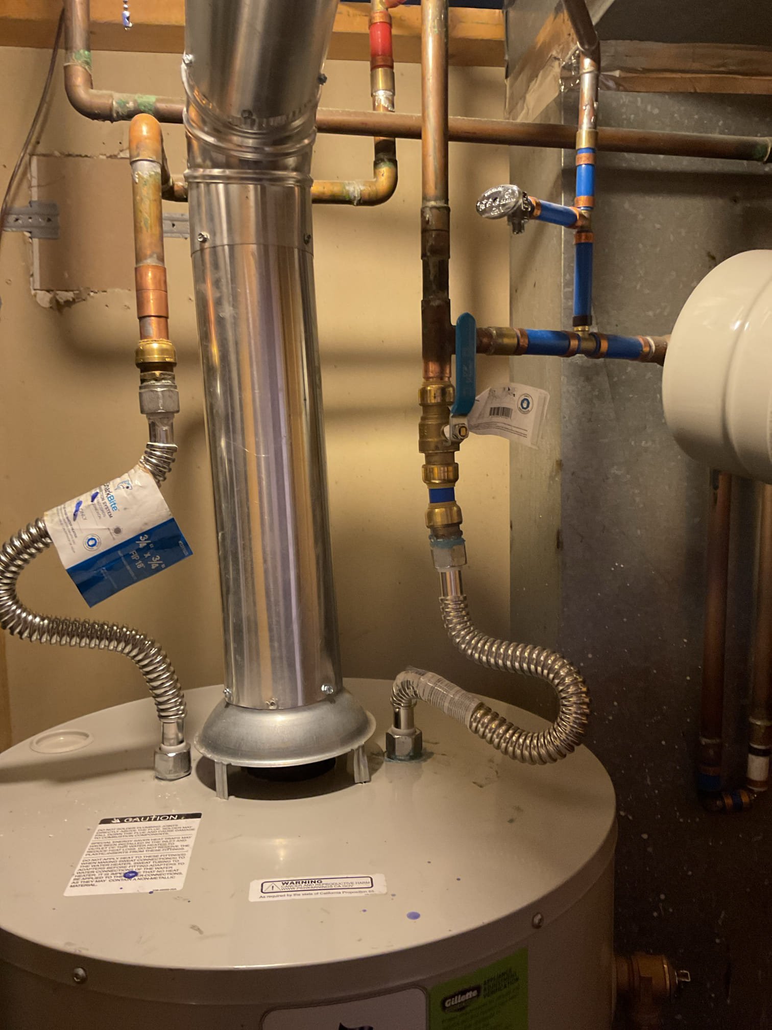 A gleaming, new water heater installed in a clean, well-lit space in San Diego. Copper pipes are neatly connected, showcasing professional water heater installation service. The background suggests a modern home, implying reliability and efficiency from a trusted water heater installation company.