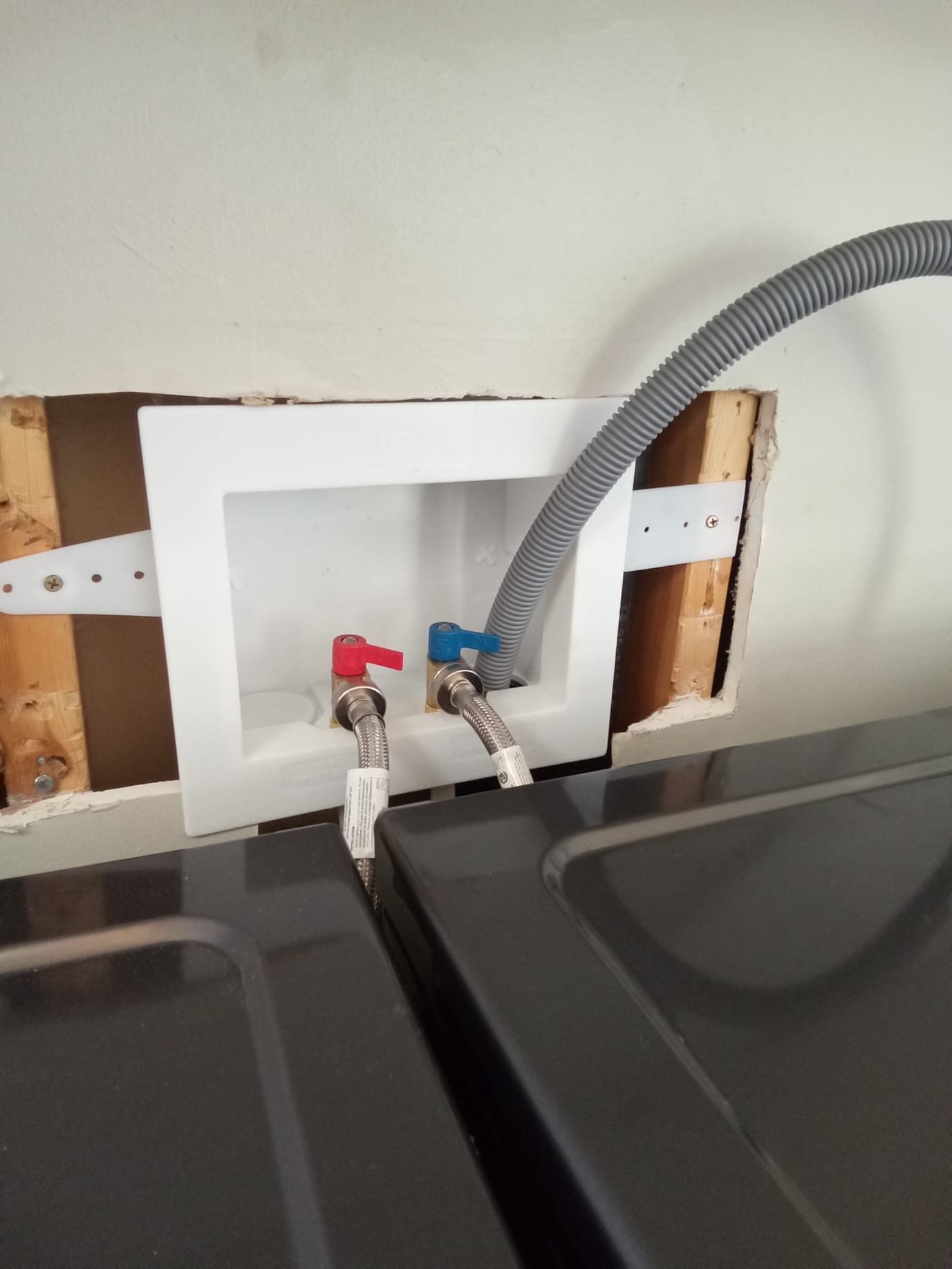 Close-up of a sparkling clean tub faucet with a single, perfect droplet suspended, not yet falling. The polished chrome reflects the bright, uncluttered bathroom, suggesting a leak-free, well-maintained fixture and the peace of mind from a successful leaky faucet repair or leaky shower faucet repair.