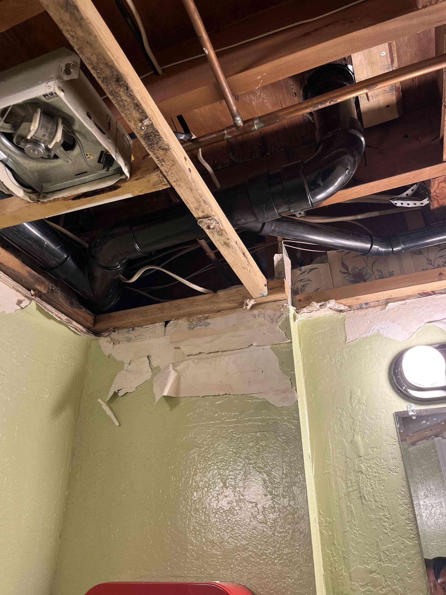 Image of a plumber expertly using a plumbing snake to clear a clogged drain, with a 24/7 service badge subtly displayed. The setting is a clean, modern bathroom, emphasizing the benefit of a quick and reliable solution to plumbing emergencies.