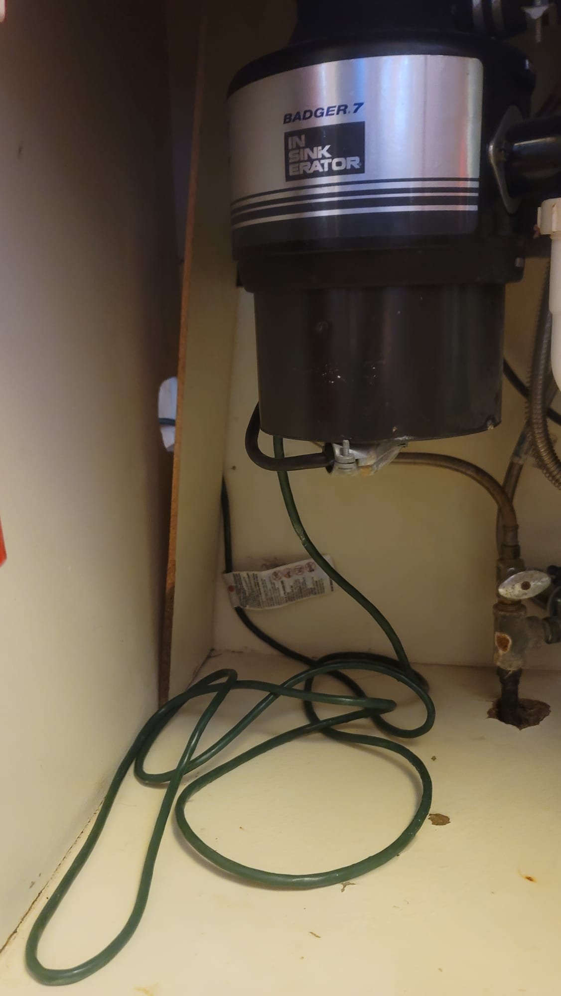 A friendly plumber in a clean uniform smiles while expertly repairing pipes in a bright, modern home. Spotless tools and organized workspace highlight professionalism and respect for your property. Call a residential plumbing company today!