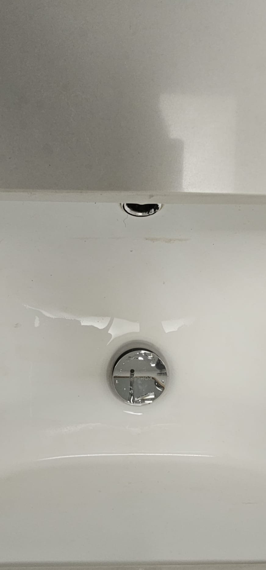 Close-up of a plumber's hands expertly connecting pipes beneath a sink, part of a garbage disposal repair. Bright, clean pipes suggest efficient plumbing drain repair and highlight the benefits of hiring local plumbing repair services for lasting solutions.